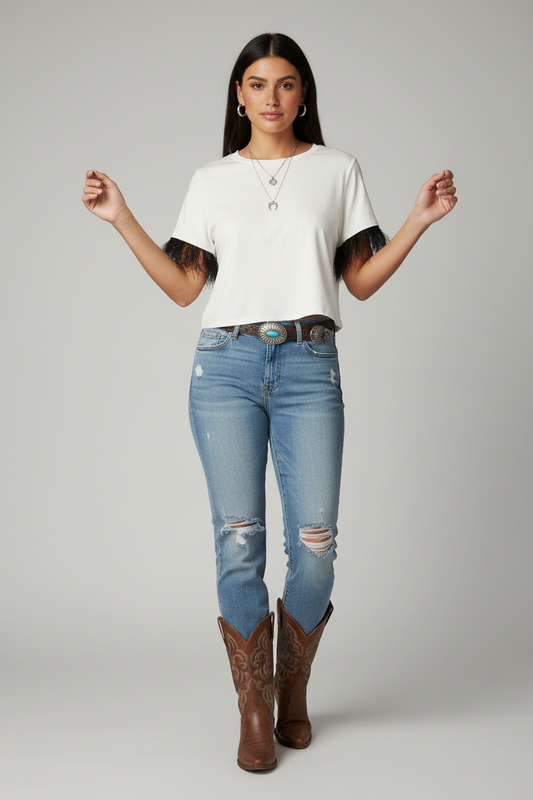 Model wearing white crop top with black fringe sleeves in casual western style